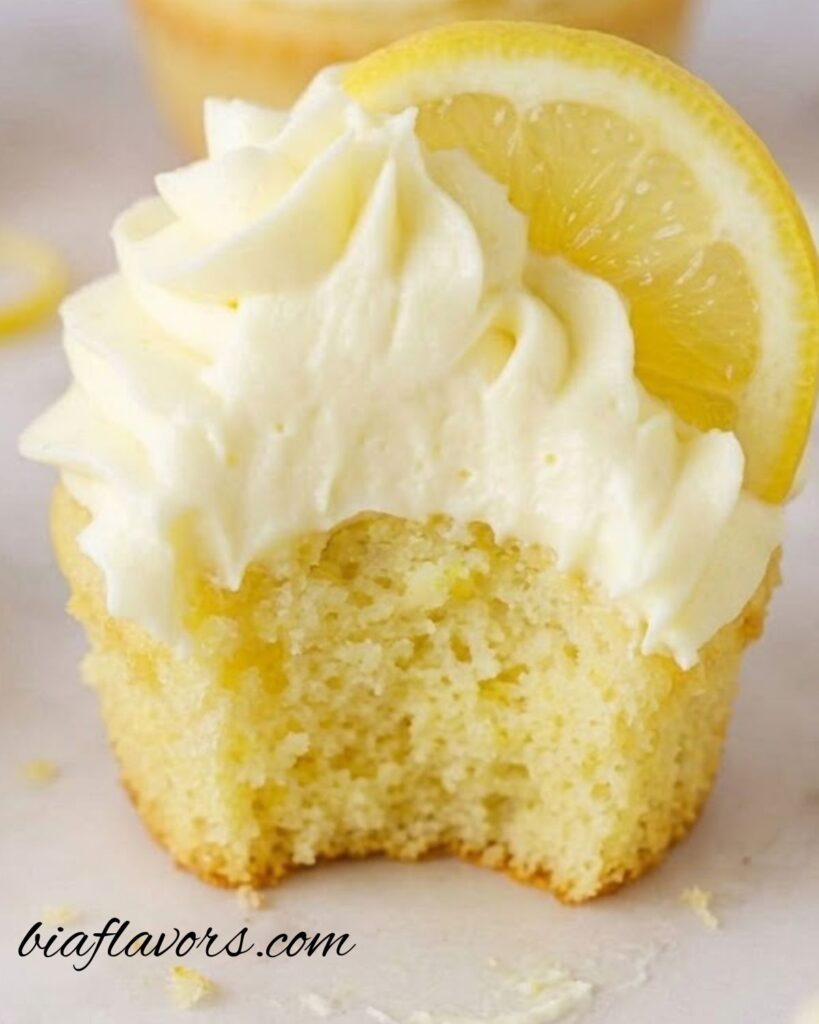 Soft and moist lemon cupcakes with lemon buttercream frosting on a white plate