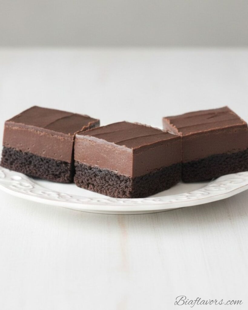 _Macro close-up side view of frosted fudge brownie showing ultra dark dense fudgy base and thick smooth chocolate frosting layer with clean cut edges (1)