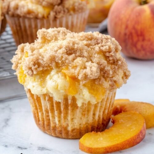 Homemade peach cobbler muffins served warm with a crispy streusel topping