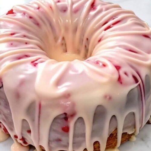 Slice of strawberry pound cake showing soft texture and fresh strawberries