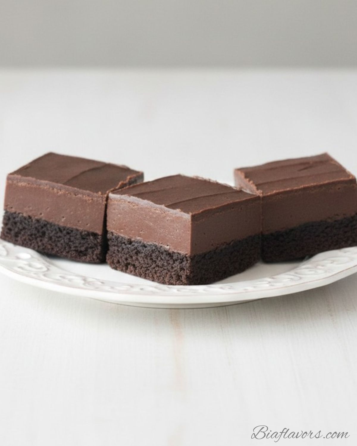 _Macro close-up side view of frosted fudge brownie showing ultra dark dense fudgy base and thick smooth chocolate frosting layer with clean cut edges (1)