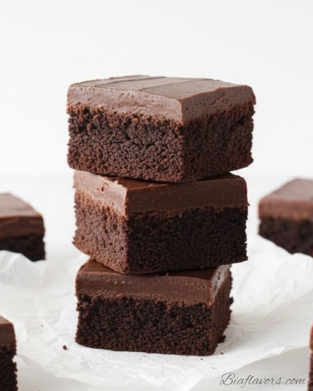 : Rich Nutella Fudge Brownies sliced into squares showing three chocolate layers on white marble surface