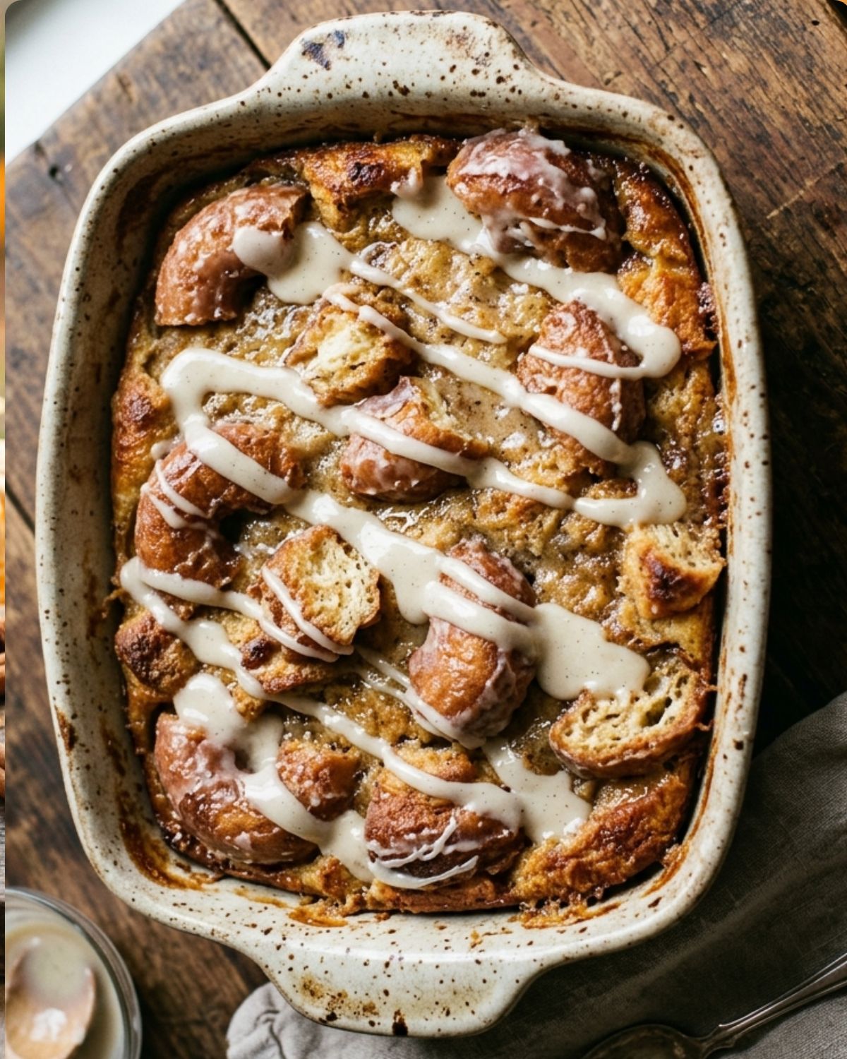 Donut bread pudding in a baking dish with vanilla glaze drizzled on top